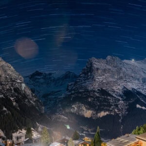 Fine Art Print des nächtlichen Alpenpanoramas mit Sternenspuren über Grindelwald – hochwertiger Kunstdruck der Schweizer Berge.