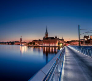 Fine-Art-Print Riddarholmen Skyline in Stockholm bei Nacht mit malerischer Spiegelung auf dem Wasser, erhältlich als hochwertiger Kunstdruck.