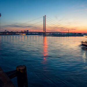 Rheinlandschaft in Düsseldorf mit Frachtschiff bei Sonnenuntergang – Fine Art Fotografie für Kunstdrucke mit Bewegung