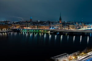 Fine-Art-Print nächtliches Stadtpanorama Stockholm im Winter mit leuchtender Skyline und Spiegelung, erhältlich als hochwertiger Kunstdruck.