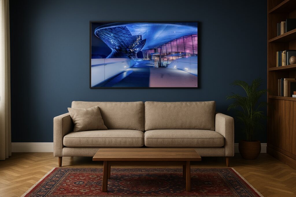 Mockup: BMW Museum München nachts, futuristische Architektur, großes Foto über Sofa an blauer Wand.