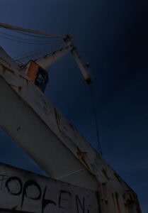 Fine Art Print eines nächtlichen Hafenkrans im Industriehafen Düsseldorf mit Sternenhimmel – stimmungsvolle Langzeitbelichtung aus der Froschperspektive.