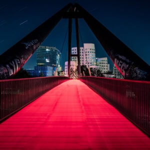 Fine Art Print der Medienhafen-Brücke in Düsseldorf bei Nacht – mit revolutionärer Lichtspur-Technik und künstlerisch gestalteter Bodenstruktur.