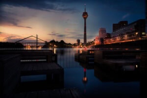 Fine Art Print der künstlerischen Spiegelung des Düsseldorfer Rheinturms im Medienhafen bei Abendlicht und ruhigem Wasser – architektonisch harmonisch.