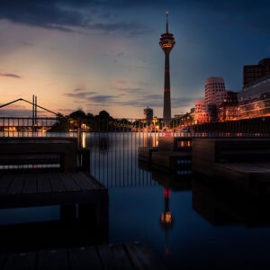 Fine Art Print der künstlerischen Spiegelung des Düsseldorfer Rheinturms im Medienhafen bei Abendlicht und ruhigem Wasser – architektonisch harmonisch.