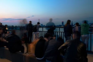 Fine Art Print: Langzeitbelichtung am Rheinufer Düsseldorf mit verschwommenen Menschen als künstlerisches Stilmittel bei Sonnenuntergang.