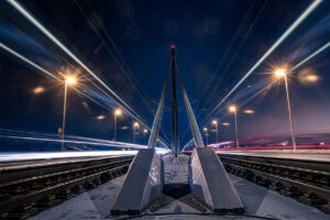 Fine Art Print: Symmetrische Langzeitbelichtung auf der Oberkasseler Brücke mit eindrucksvollen Lichtspuren und urbaner Nachtstimmung.