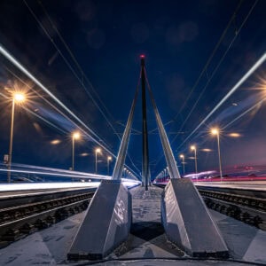 Fine Art Print: Symmetrische Langzeitbelichtung auf der Oberkasseler Brücke mit eindrucksvollen Lichtspuren und urbaner Nachtstimmung.