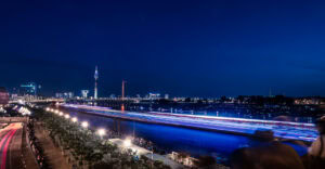 Fine Art Print mit Lichtspuren auf dem Rhein und der Düsseldorfer Skyline bei Nacht – Blaue Stunde trifft urbane Dynamik und Bildtiefe.