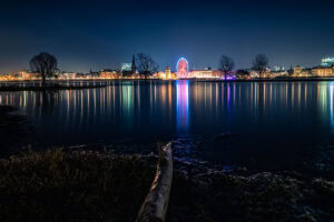 Fine Art Print der nächtlichen Düsseldorfer Skyline mit Riesenrad, Hochwasser und farbenfroher Spiegelung – Langzeitbelichtung im Winter.