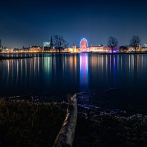 Fine Art Print der nächtlichen Düsseldorfer Skyline mit Riesenrad, Hochwasser und farbenfroher Spiegelung – Langzeitbelichtung im Winter.