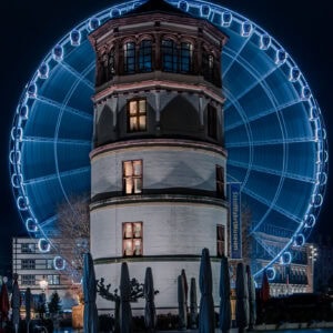 Fine Art Print vom Schlossturm Düsseldorf bei Nacht, kombiniert mit Lichtspuren des Riesenrads in Langzeitbelichtung – ein ikonisches Stadtmotiv.