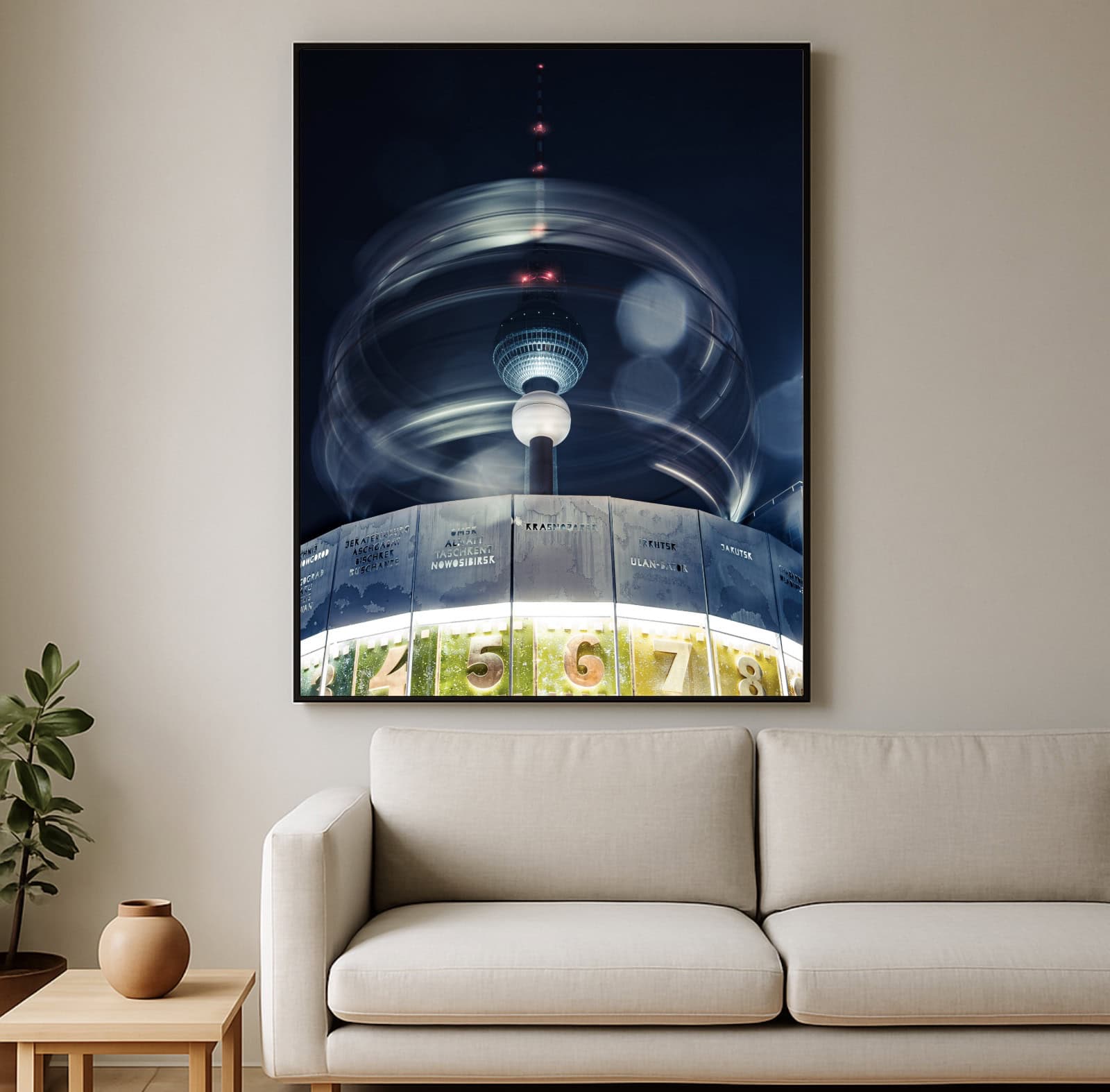 Fine-Art-Wandbild mit Weltzeituhr und Fernsehturm in Berlin bei Nacht; Langzeitbelichtung mit Lichtkreisen, gerahmt über beigem Sofa im Wohnzimmer.