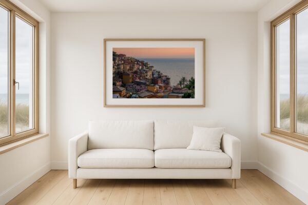 Helles Wohnzimmer im Strandhaus-Look mit gerahmtem Wandbild „Manarola, Cinque Terre“, Fine-Art Print über Sofa.