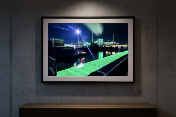 Gerahmter Fine-Art-Print „Lausward Düsseldorf“ mit grüner Lichtspur und Industriehafen, Spotbeleuchtung an Betonwand (Galerie-Mockup)