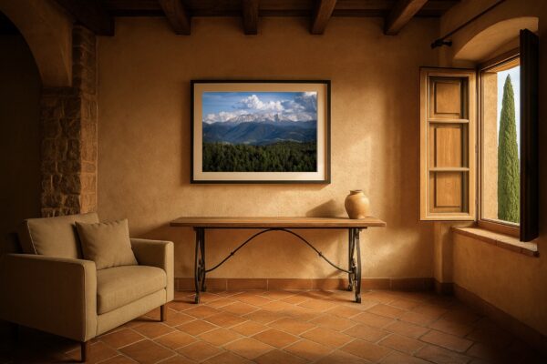 Mockup: Gerahmtes Wandbild mit Blick von Oberbozen/Ritten auf die Dolomiten, gezeigt in mediterranem Raum mit Fenster und Holzbalkendecke.