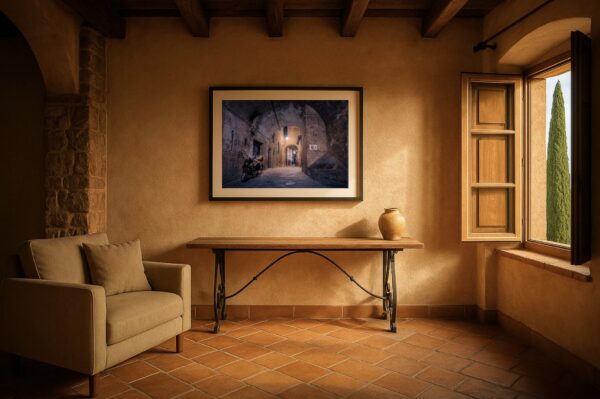 Mediterranes Interieur mit Terrakotta-Boden und gerahmtem Wandbild einer nächtlichen Gewölbegasse in Siena mit Vespa.