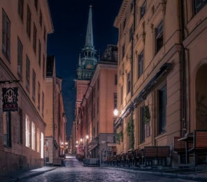 Nachtbild einer Gasse auf Riddarholmen mit Blick auf den Turm der Riddarholmskyrkan, Kopfsteinpflaster.