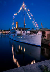 Motala Express in Stockholm bei blauer Stunde – Lichterkette und Spiegelungen im Hafen von Nybroviken.