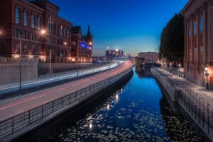 Langzeitbelichtung mit Lichtspuren am Norstedts-Gebäude, Brücke und Kanal in Stockholm.