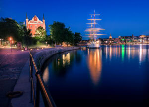 Segelschiff AF Chapman vor Skeppsholmen mit Spiegelungen, Blaue Stunde in Stockholm.