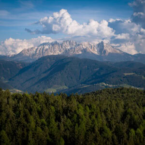 Oberbozen, Südtirol – Luftaufnahme mit Blick auf Dolomiten, Waldsaum und Wolkentürme, klare Staffeln.