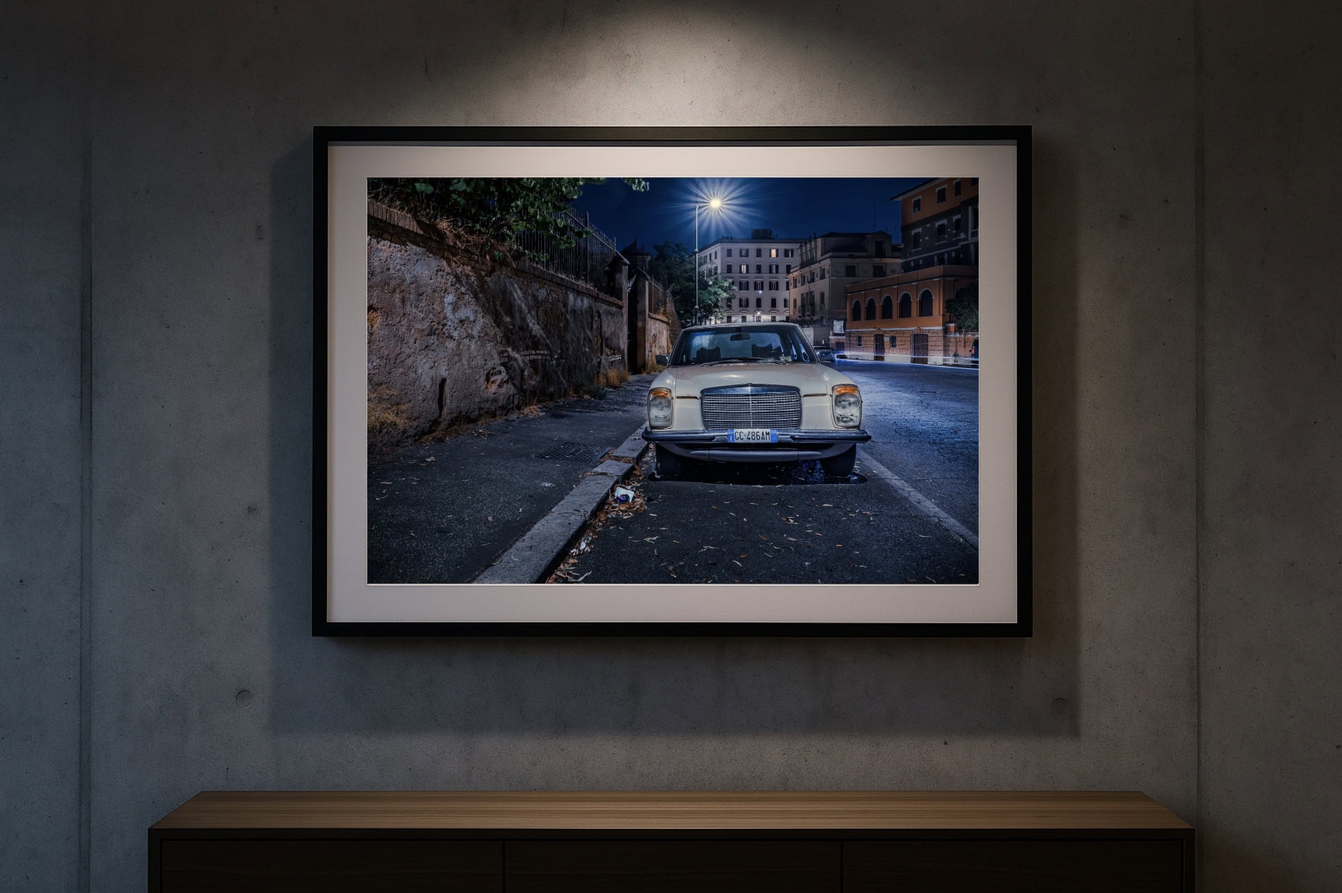 Gerahmter Fine-Art-Print „Mercedes-Oldtimer in römischer Nebenstraße bei Nacht“ an Betonwand mit Spotbeleuchtung; klarer, moderner Galerie-Look.