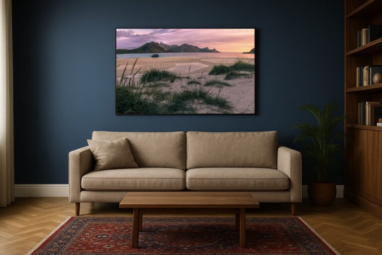 Sanddünen mit Strandgräsern am Hauklandstrand, sanftes rosa Abendlicht, Berge und ruhige See im Hintergrund.