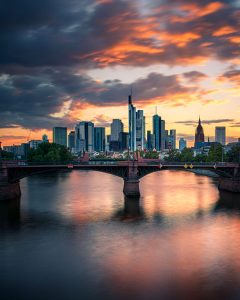 Frankfurter Skyline mit Brücke über dem Main bei farbigem Sonnenuntergang