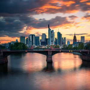 Frankfurter Skyline mit Brücke über dem Main bei farbigem Sonnenuntergang