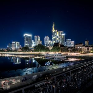 Nachts beleuchtete Skyline von Frankfurt am Main mit Brücke und Mainufer