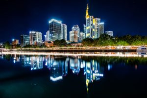 Nachts beleuchtete Skyline von Frankfurt mit Reflexion im ruhigen Mainufer
