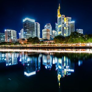 Nachts beleuchtete Skyline von Frankfurt mit Reflexion im ruhigen Mainufer