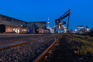 Industriehafen in Düsseldorf mit Hafenkran, Schrottplatz und Skyline in der blauen Stunde