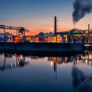 Industriehafen in Düsseldorf mit Containern und Kränen im Sonnenuntergang, Spiegelung im Hafenbecken
