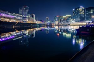 Nächtlicher Blick über den Düsseldorfer Medienhafen mit Lichtern und Spiegelungen im Wasser