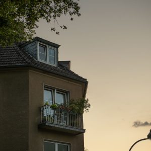 Altbau-Balkon mit Pflanzen in Düsseldorf Oberkassel vor stillem Abendhimmel