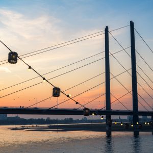 Rheinkniebrücke in Düsseldorf bei Sonnenuntergang mit Lichterkette am Rheinufer