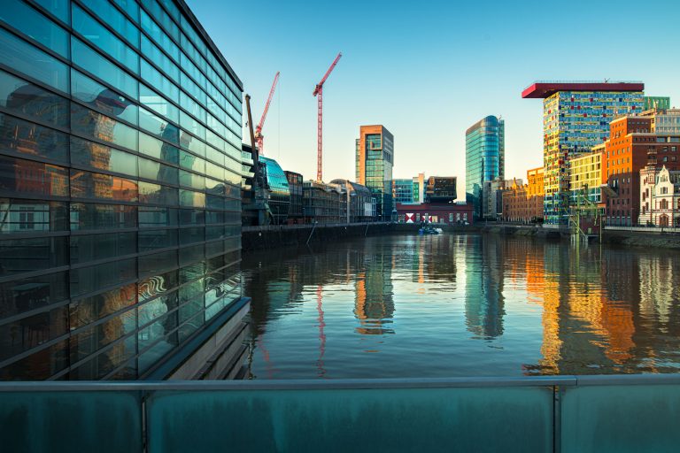 Moderner Düsseldorfer Medienhafen mit Spiegelungen im Wasser bei klarem Morgenlicht