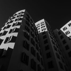Schwarzweißfotografie der geschwungenen Gehry Bauten in Düsseldorf mit starkem Licht-Schatten-Kontrast