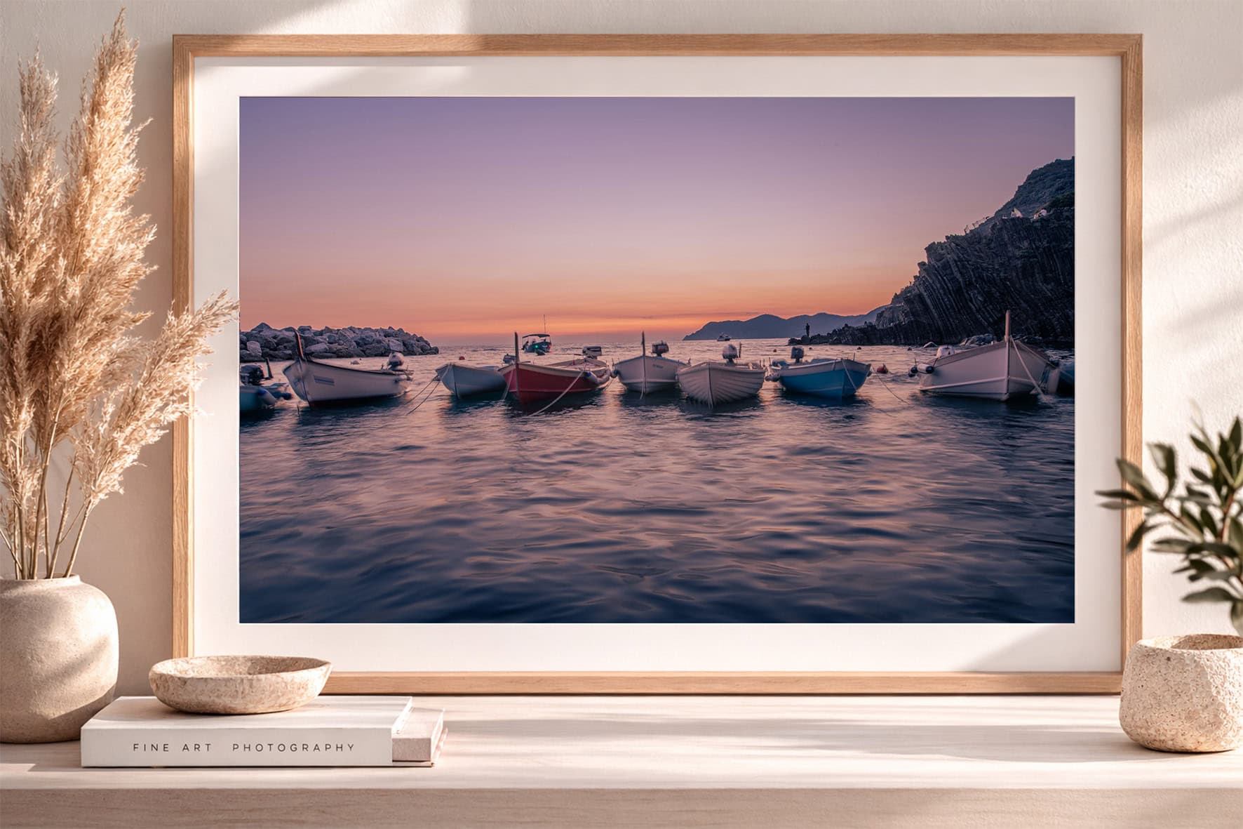 Fotografie von kleinen Booten im ruhigen Meer bei Sonnenuntergang, in hellem Holzrahmen auf Sideboard mit Deko