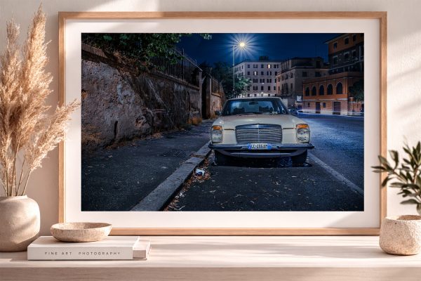 Fotografie eines cremefarbenen Oldtimers in einer nächtlichen Stadtstraße, im Holzrahmen auf Sideboard mit Deko gezeigt