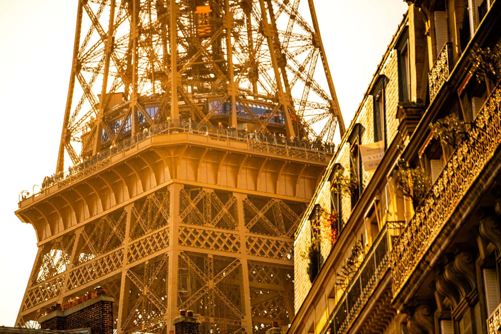 Eiffelturm in Paris mit nahen Hausfassaden im warmen goldenen Licht