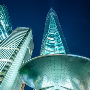 Wolkenkratzer in Paris La Défense bei Nacht aus der Froschperspektive mit beleuchteten Glasfassaden