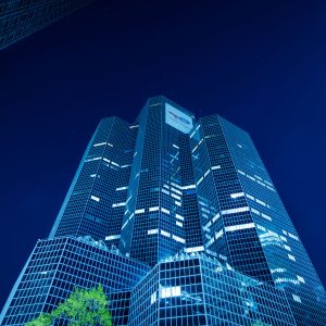 Gläserne Wolkenkratzer in Paris La Défense bei Nacht mit blauem Licht und beleuchteten Fenstern
