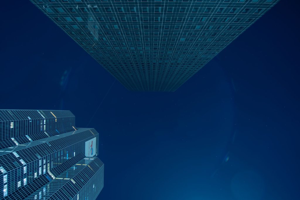 Blick nach oben auf zwei Wolkenkratzer in Paris La Défense bei Nacht vor tiefblauem Himmel