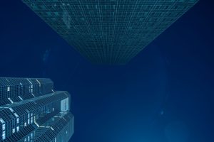 Blick nach oben auf zwei Wolkenkratzer in Paris La Défense bei Nacht vor tiefblauem Himmel