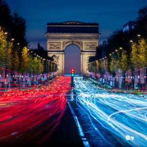 Triumphbogen in Paris mit roten und blauen Lichtspuren auf den Champs-Élysées bei Nacht