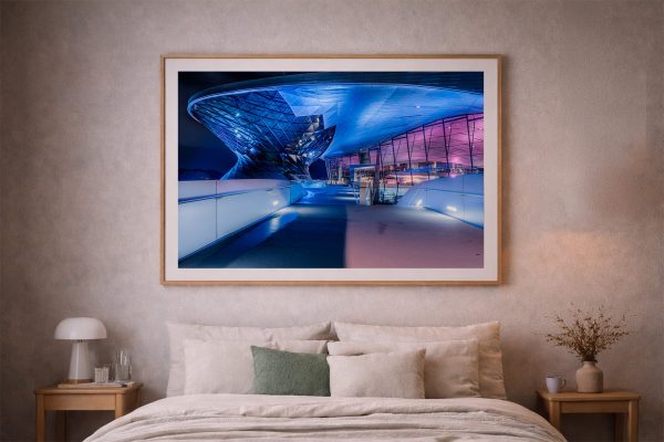 Fotografie einer futuristischen, blau-violett beleuchteten Architektur über einem Weg, gerahmt über einem Bett in einem ruhigen Schlafzimmer