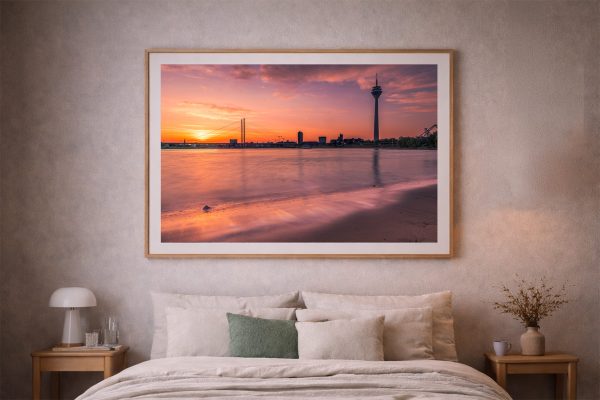 Großer gerahmter Fotodruck mit Stadt-Silhouette, Brücke und Fluss im warmen Sonnenuntergang über einem Bett im gemütlichen Schlafzimmer
